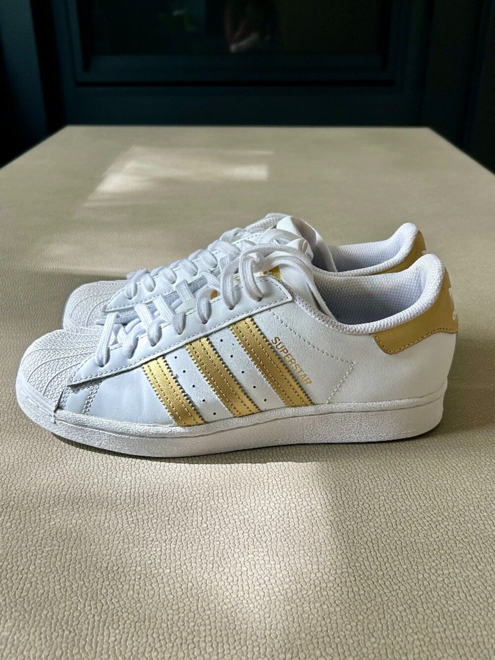 Adidas Superstar Sneakers in White/Gold Stripes